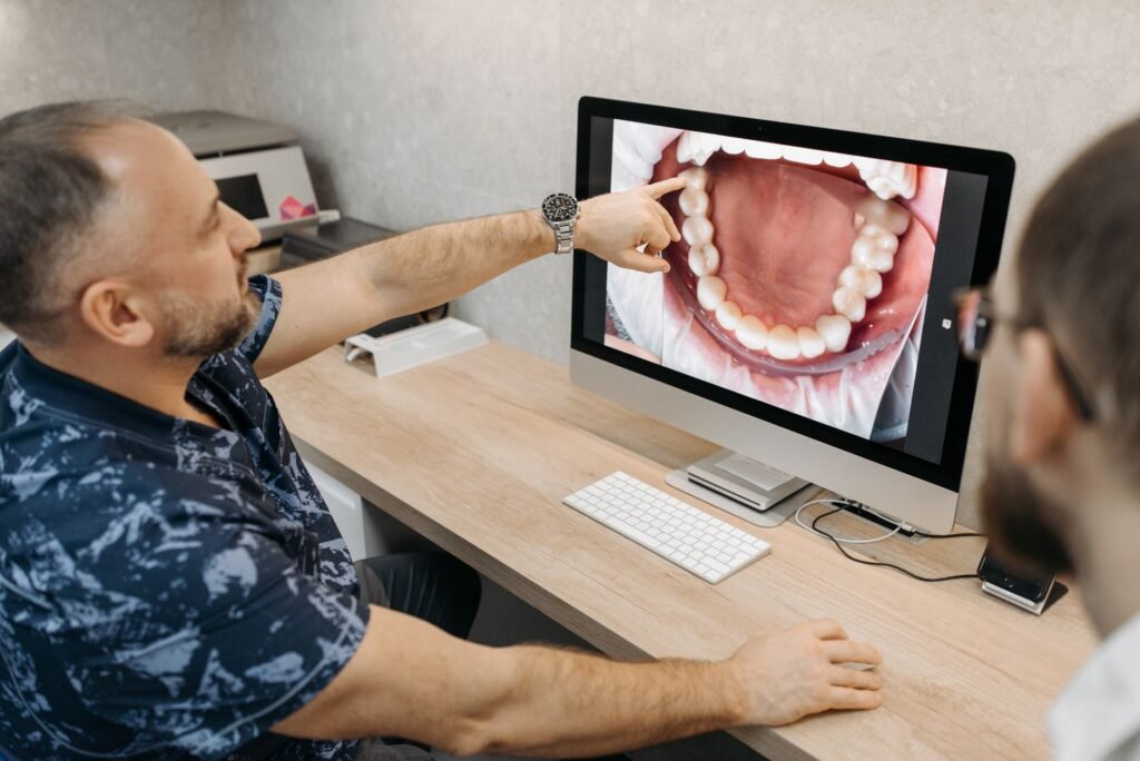 Odontólogo analizando imágenes de escaneo intraoral en una pantalla en la clínica dental