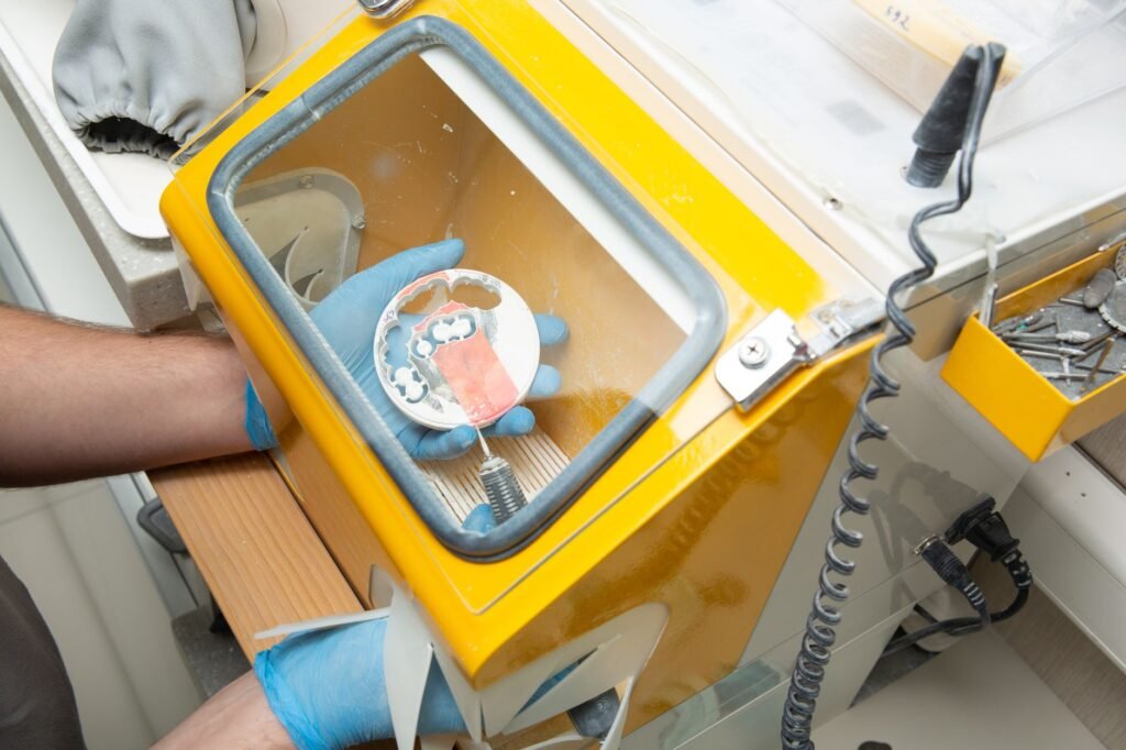 Técnico dental trabajando con una máquina de prótesis en un laboratorio moderno